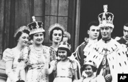 Las princesas Isabel y Margarita de Gran Bretaña aparecen en el balcón del Palacio de Buckingham, el día de la coronación de su padre, el rey Jorge VI, el 12 de mayo de 1937. (AP/Archivo)