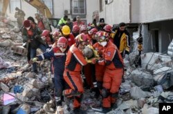 Rescatistas sacan a un migrante sirio de entre los escombros de un edificio derruido en Antioquía, en el sur de Turquía, el domingo 12 de febrero de 2023 (Cem Tekkesinoglu/DIA images via AP)