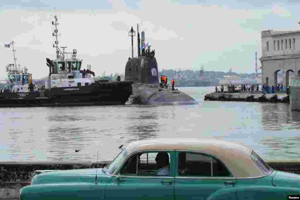 Un coche antiguo pasa mientras el submarino ruso de misiles de crucero de propulsión nuclear Kazán atraca en la bahía de La Habana, Cuba, el 12 de junio de 2024. REUTERS/Alexandre Meneghini