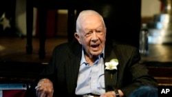 El expresidente Jimmy Carter reacciona mientras su esposa Rosalynn Carter habla durante una recepción para celebrar su 75 aniversario de bodas, el 10 de julio de 2021, en Plains, Georgia. (Foto AP/John Bazemore).