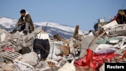 Un hombre reposa sobre las ruinas en la ciudad turca de Kahramanmaras.