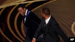 Will Smith, derecha, golpea al presentador Chris Rock en el escenario al presentar el premio a mejor largometraje documental en los Oscar. (Foto AP/Chris Pizzello)