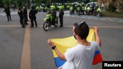 Un joven protesta frente a la policía antimotines en Cali, Colombia, este 9 de mayo. (REUTERS/Juan B Diaz)