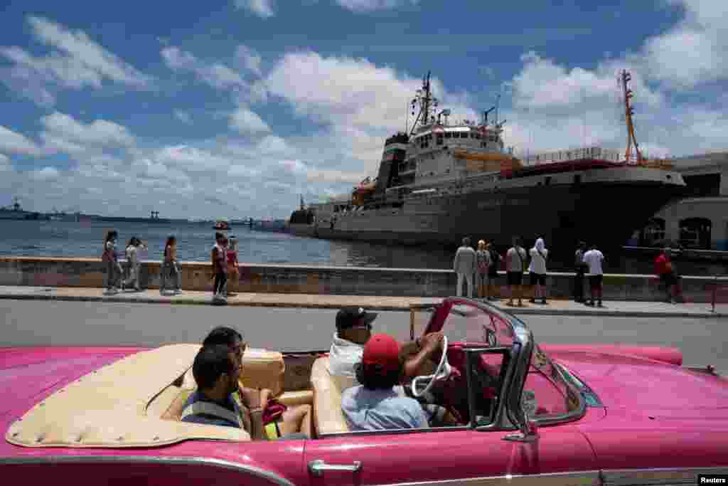 Los turistas pasan por el submarino ruso de misiles de crucero de propulsión nuclear Kazán y el remolcador Nikolay Chiker, atracado en la bahía de la Habana, Cuba, el 13 de junio de 2024. REUTERS/Alexandre Meneghini