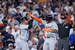 Entrenador de los Tigres de Detroit Joey Cora celebra con Andy Ibáñez que éste bateara un doble contra los Astros de Houston. 02/10/2024, (AP Foto/Kevin M. Cox)