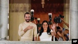 El presidente de El Salvador Nayib Bukele y su esposa Gabriela Rodriguez saludan a sus seguidores desde el balcón del palacio de gobierno. (AP/Moises Castillo)